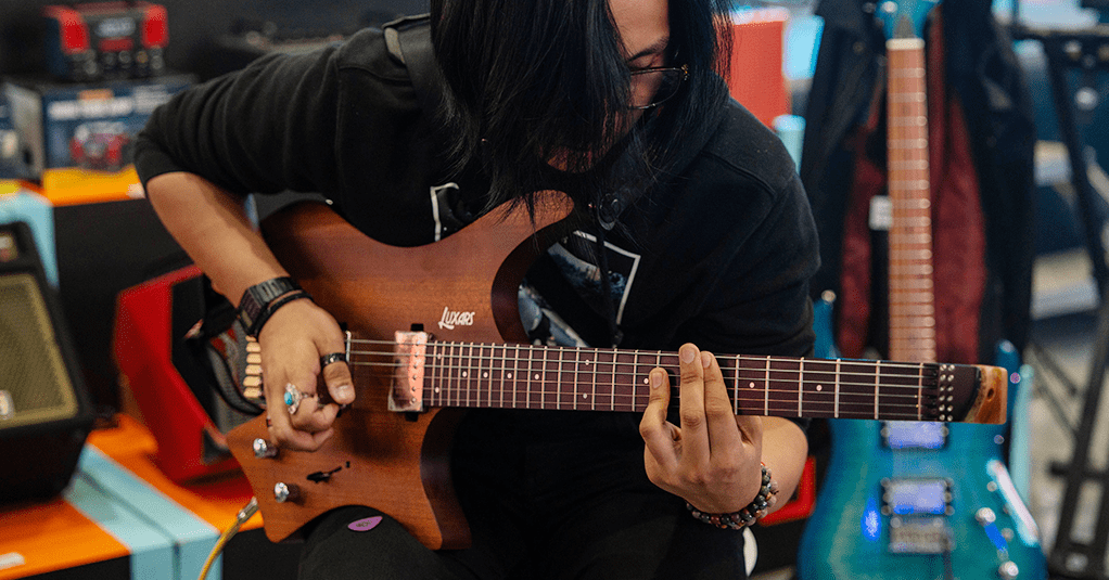 Men playing Luxars Electronic Guitar